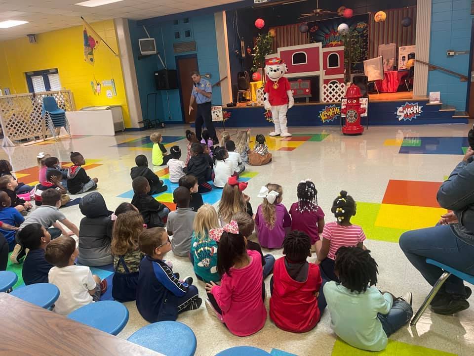 students at fire safety assembly with fireman and marshall
