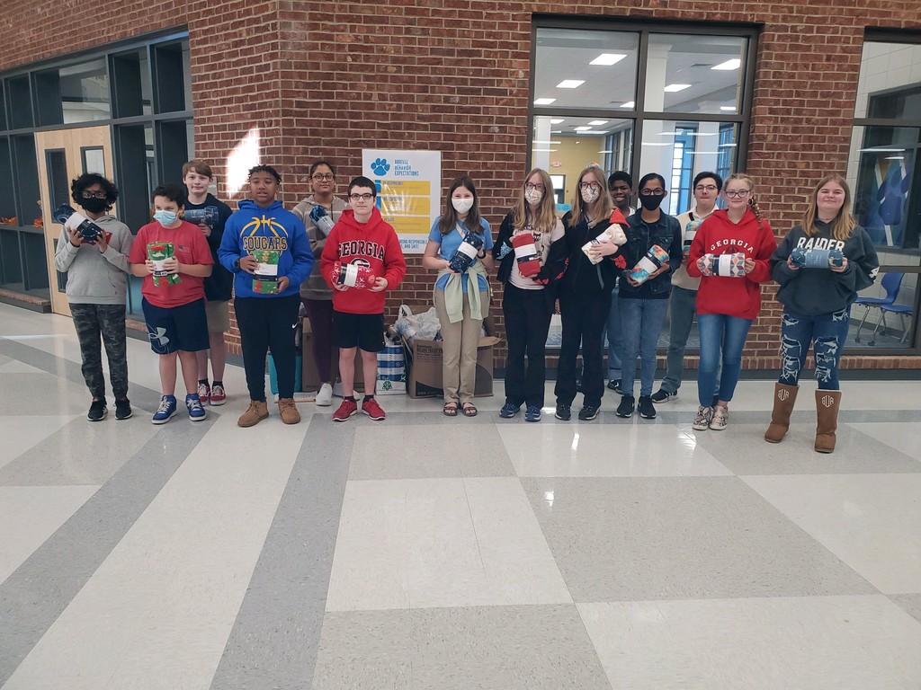 Students are pictured with blankets to donate. 